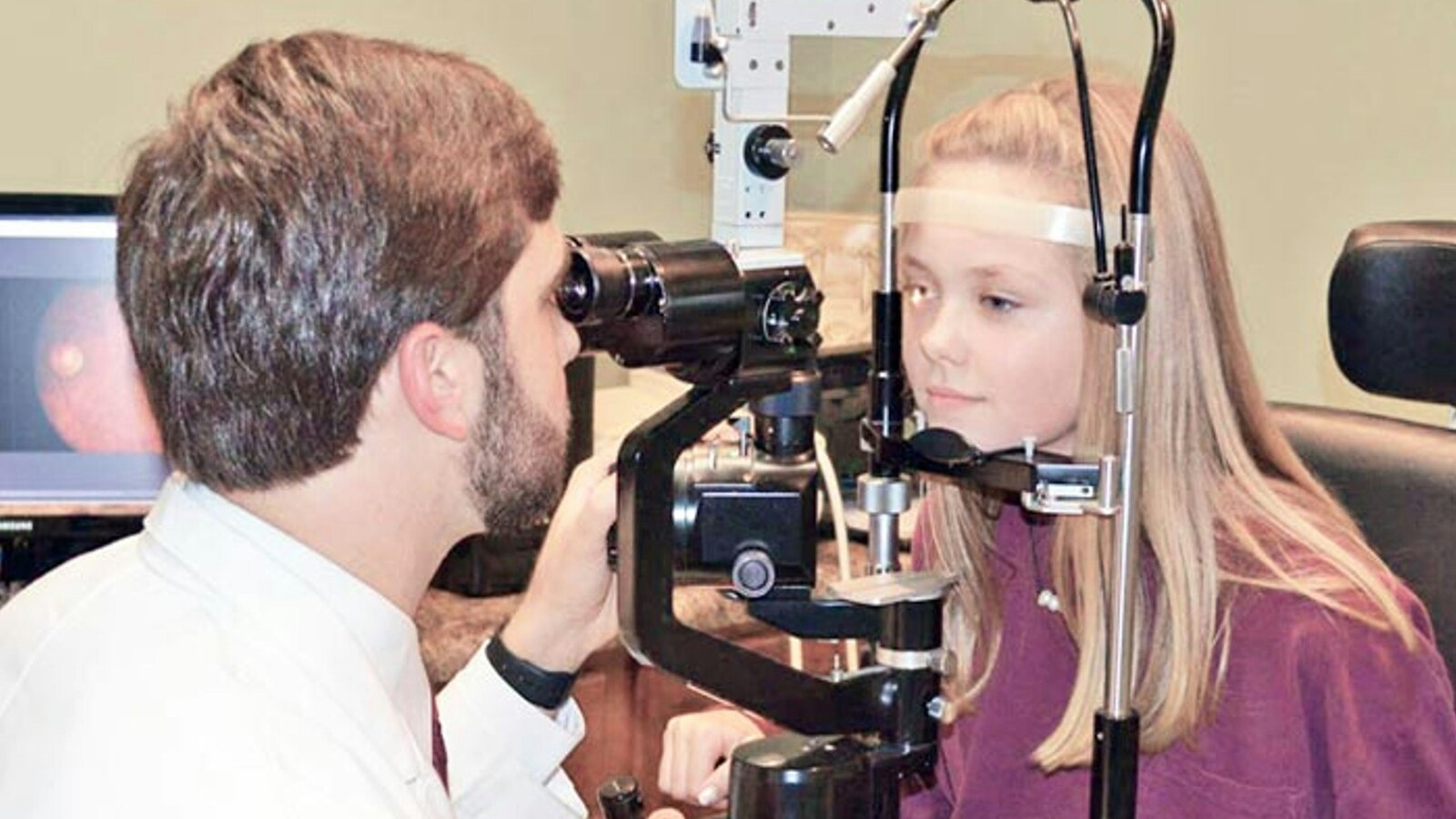 Optometrist examining a patient at the slit lamp